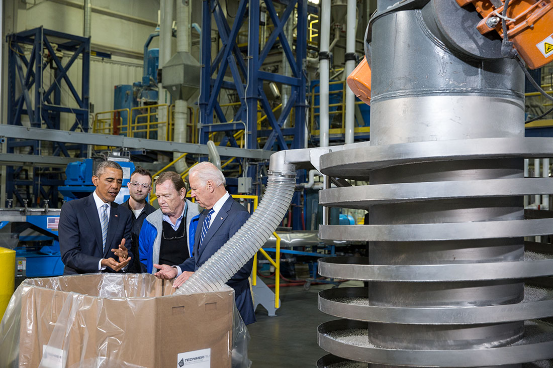 President Obama and Vice President Biden view an extruder machine that combines raw materials to create a specific product, during a tour of Techmer PM
